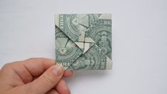 someone is holding an origami piece in their hand and it looks like money