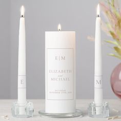 three white candles sitting next to each other on a table