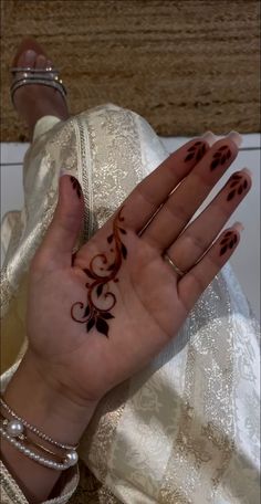 a woman's hand with henna tattoos on it