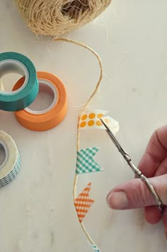 someone is using scissors to cut the twine off of some tape and another pair of scissors