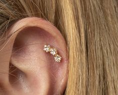 a woman's ear with three small flowers on it