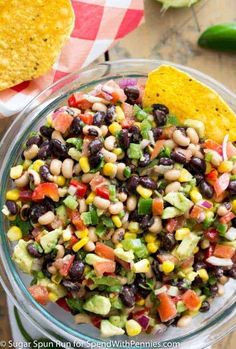 a glass bowl filled with black - eyed beans, corn and avocado salsa