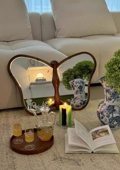 an open book sitting on top of a table next to two vases filled with flowers