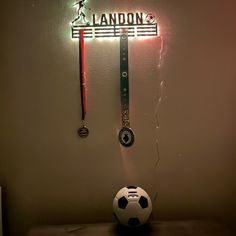 a soccer ball sitting on top of a table next to a neon sign that says landon