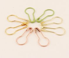 five pairs of scissors sitting in a circle on top of a white surface with green handles