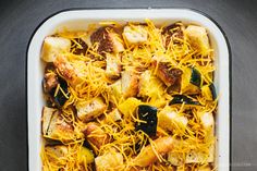 a casserole dish with cheese, bread and other toppings in it on a table