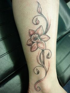 a woman's foot with a flower tattoo on it