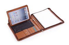 an open laptop computer sitting on top of a brown leather notebook cover with a notepad and pen