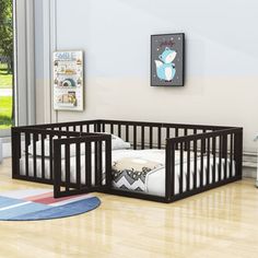 two baby cribs sitting on top of a hard wood floor next to a window