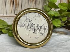 an image of a sheep in the woods on a pocket watch with leaves around it