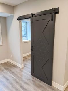 an empty room with a sliding door in the center and wood floors on both sides