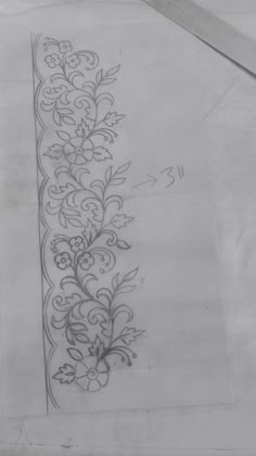 a drawing of a floral design on white paper with a pair of scissors next to it