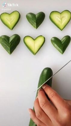 someone cutting cucumbers into hearts with scissors