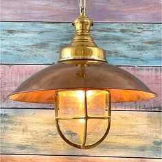 a light hanging from the side of a wooden wall with multi colored boards behind it