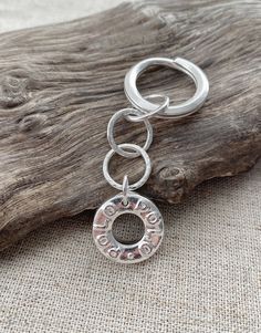 a key chain with the word love on it and a circle charm hanging from it