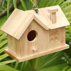 a wooden bird house hanging from a tree