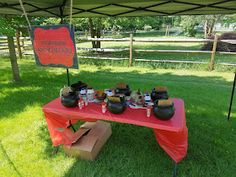 a red table topped with lots of food under a tent