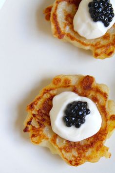 two pancakes with blackberries and cream on them