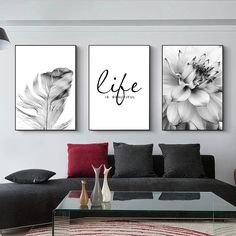 three black and white paintings on the wall above a couch