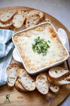 a plate with bread slices and a bowl of cheese dip on it next to garlic bread