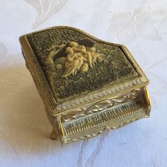 an ornately decorated box sitting on top of a white cloth covered tablecloth,