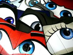 several paper masks with blue eyes on them