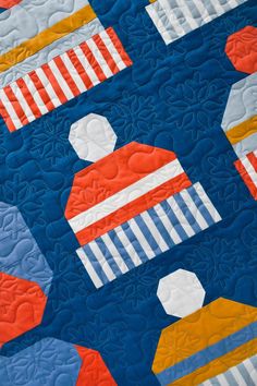 a blue quilt with orange and white designs on it