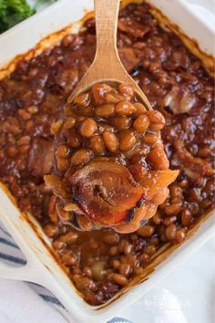 a spoon full of baked beans in a casserole dish