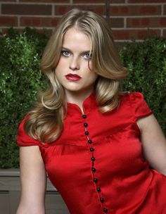 a woman in a red dress posing for a photo with her hands on her hips