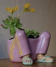 a purple planter with yellow flowers in it