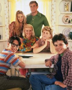 a group of people sitting around a kitchen table