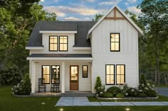 a white two story house with black shutters on the front and side windows at night