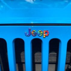 jeep logo on the front grill of a blue car