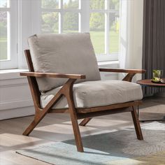 a chair with a pillow on it in front of a window and a coffee table