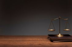 two books and a scale on a wooden table in front of a dark background,