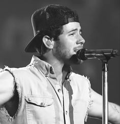 a man wearing a hat singing into a microphone