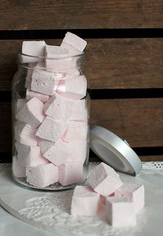 a jar filled with marshmallows sitting on top of a table