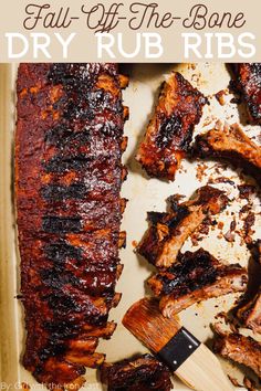 bbq ribs and barbecue sauce on a baking sheet with a spatula next to them