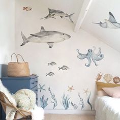 a child's bedroom decorated in blue and white with shark, octopus, sea creatures and fish wall decals