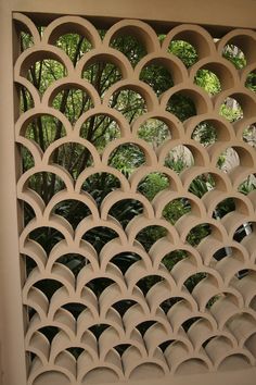 an intricately designed wall with trees in the background