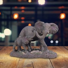 an elephant and her baby statue on a wooden table