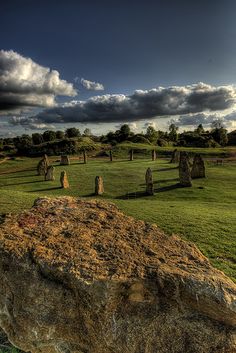 a large rock sitting on top of a lush green field