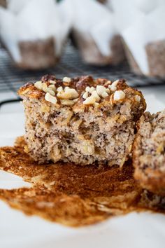 a close up of a piece of cake on a plate with other muffins in the background