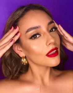 a woman with red lipstick and gold hoop earrings