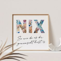 a framed print with the words mix on it next to a potted plant