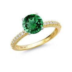 a gold ring with a green stone and white diamonds on the band, set in 18k yellow gold