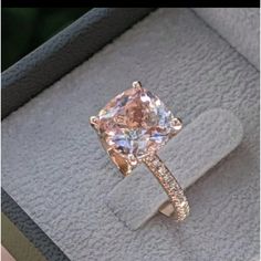 an engagement ring in a box with a pink diamond on the front and white diamonds on the back