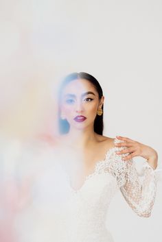 a woman in a white dress posing with her hands on her hips and looking off to the side