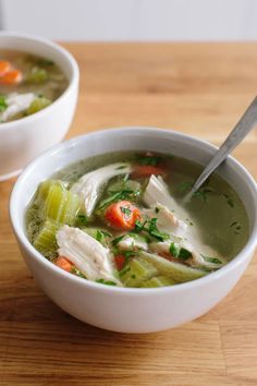 two bowls filled with soup on top of a wooden table