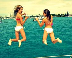 two girls jumping in the air on a boat